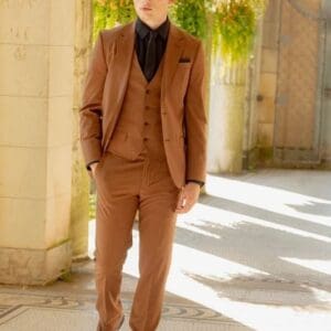 A man in brown suit standing on the sidewalk.