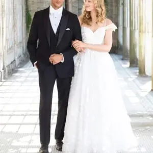 A man and woman in wedding attire walking down the aisle.