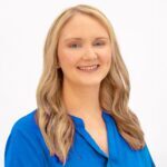 Smiling blonde woman headshot in blue blouse