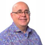 Smiling bald man wearing glasses and colorful shirt