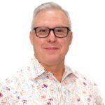 Smiling man wearing floral shirt and glasses